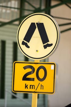 yellow 20 km speed limit sign pedestrian zone