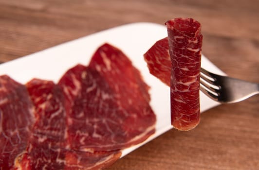 Dry-cured Spanish ham, Serrano ham, Bellota ham, Italian prosciutto crudo or Parma ham, wagyu slice. High quality photo