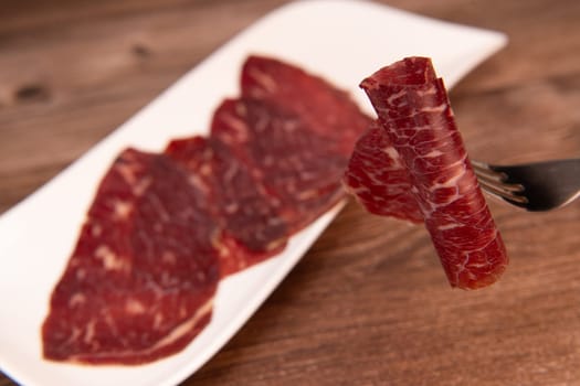 Dry-cured Spanish ham, Serrano ham, Bellota ham, Italian prosciutto crudo or Parma ham, wagyu slice. High quality photo