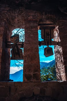 Religious architecture, ancient church bells photo. Sant Miquel del Fai is an 11th-century Benedictine monastery. Church set in cliffs, Catalonia mountains. High quality picture for wallpaper, article