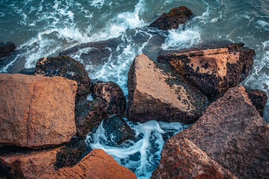 Mediterranean winter stormy seaside. Close up water with stones on the beach concept photo. Underwater rock. The view from the top, nautical background. High quality picture for wallpaper