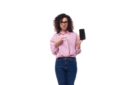 young charming caucasian woman with curly hair dressed in a striped shirt advertises a phone with a mockup.