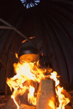 cooking on the campfire inside a tent in winter time