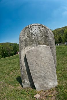 Old tomb stone in grave yard with masonic signs