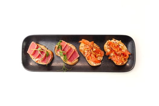 Bruschetta with salmon and tuna tartare on ciabatta toast. High quality photo