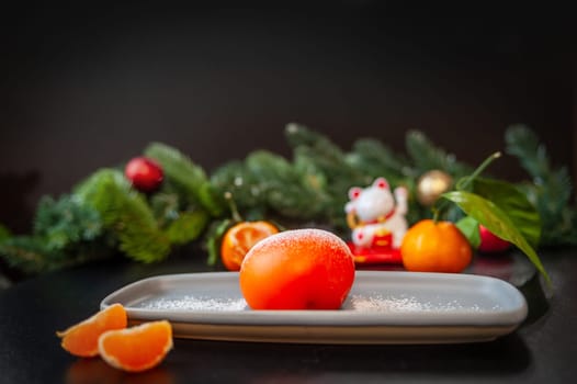 Plate with delicious mochi and tangerine on a dark Christmas background. High quality photo