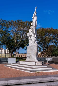 New Orleans, LA - 28 October 2023: Monument to the Immigrant sculpture by Franco Alessandrini on banks of Mississippi river in Louisiana