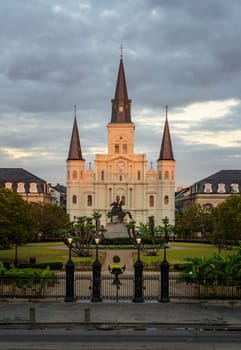 Rays from rising sun hit the facade of the Cathedral of St Louis, King of France with statue of Andrew Jackson in New Orleans in Louisiana