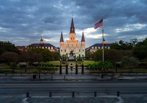 Rays from rising sun hit the facade of the Cathedral of St Louis, King of France with statue of Andrew Jackson in New Orleans in Louisiana