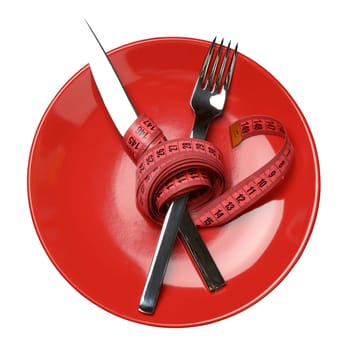 Red round plate and fork and knife wrapped in green measuring tape, weight loss concept