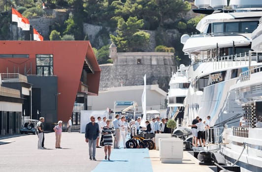 Monaco, Monte Carlo, 28 September 2022 - Invited wealthy clients inspect megayachts at the largest fair exhibition in the world yacht show MYS, port Hercules, yacht brokers, sunny weather. High quality photo