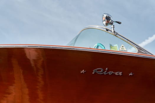 Monaco, Monte Carlo, 29 September 2022 - the wooden side of the luxury motor boat Riva in port of Hercules, sunny glare of the sun, elegance boat, glossy surfaces shine in sunny weather. High quality photo