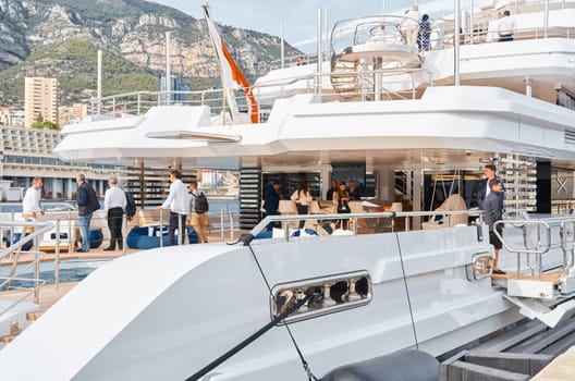 Monaco, Monte Carlo, 29 September 2022 - Invited wealthy clients inspect mega yachts at the largest fair exhibition in the world yacht show MYS, port Hercules, yacht brokers, sunny weather. High quality photo