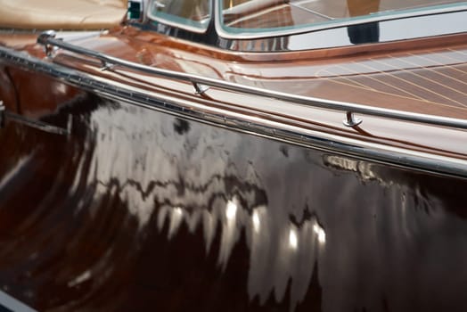 the wooden side of the luxury motor boat in port of Hercules in Monaco, sunny glare of the sun, elegance boat, glossy surfaces shine in sunny weather. High quality photo