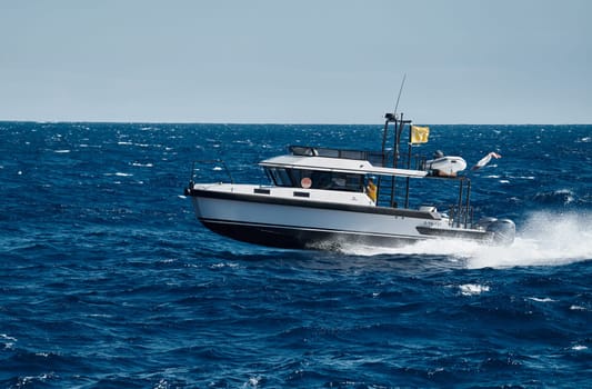 Monaco, Monte Carlo, 28 September 2022 - A motorboat with people is sailing at high speed in the sea near Monaco, island on background. High quality photo