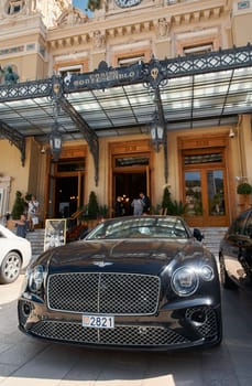 Monaco, Monte-Carlo, 29 September 2022 - Famous square Casino Monte-Carlo at sunny day, Bentley convertible, luxury cars, wealth life, tourists take pictures of the landmark. High quality photo