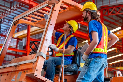 Caucasian technician worker point up and discuss with his co-worker in factory workplace area. Good management in the industrial factory concept.