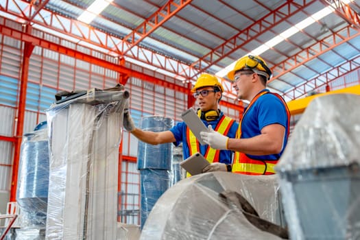 Side view of two factory workers hold tablet check and maintenance the machine in factory workplace.