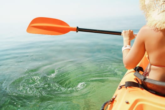 Kayak paddle sea vacation. Person paddles with orange paddle oar on kayak in sea. Leisure active lifestyle recreation activity rest tourism travel.