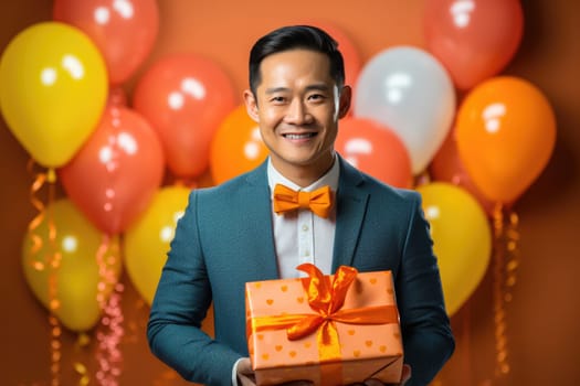 People, joy, fun and happiness concept. happy japanese birthday man holding with gift box, balloons in the background. AI Generated