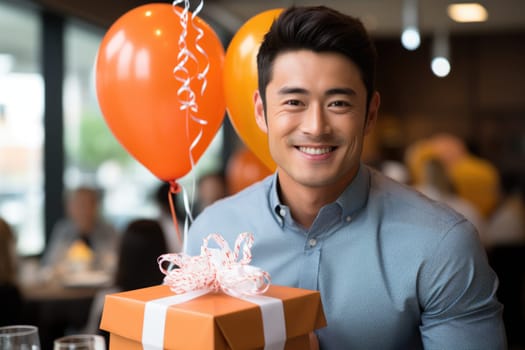 People, joy, fun and happiness concept. happy Asian birthday man holding with gift box, balloons in the background. AI Generated