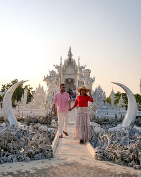 White Temple Chiang Rai Thailand, a diverse couple of men and women visit Wat Rong Khun temple in Northern Thailand.