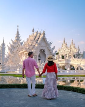 White Temple Chiang Rai Thailand, a diverse couple of European men and Asian women visit Wat Rong Khun temple, Northern Thailand.