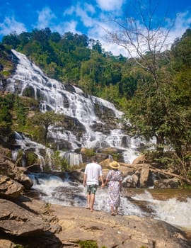 Mae Ya Waterfall Doi Inthanon National Park Thailand Chiang Mai is a beautiful waterfall in Doi Inthanon National Park in Thailand. A couple of men and a woman visiting a waterfall in Thailand