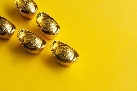 Top view of golden ingot on yellow cover background.