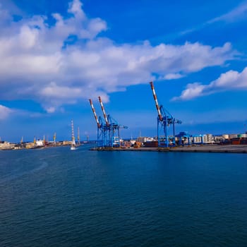 wide panoramic view of the harbor of Genoa. Blue sky blue sea white clouds and port buildings in harmony with the surrounding Mediterranean landscape High quality photo