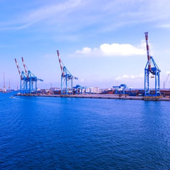 wide panoramic view of the harbor of Genoa. Blue sky blue sea white clouds and port buildings in harmony with the surrounding Mediterranean landscape High quality photo