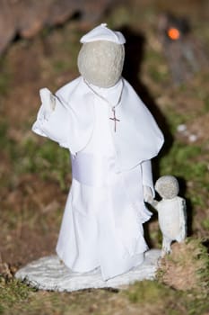 pope francis stone statue while holding children by hand