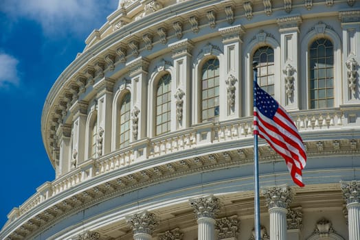 Washington DC Capitol dome detail with waving american flag.