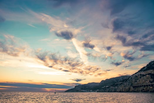 Amazing panoramic landscape of rocky shore photo. Sunrise sundown sky background with colorful clouds. Mediterranean sea. Beach concept photo. Bright seaside dusk. High quality picture for wallpaper