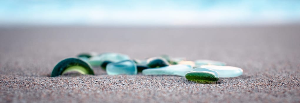 Mediterranean sea beach and colorful stones photo. Glass stones from broken bottles polished by the sea. Front view photography with blurred background. High quality picture for wallpaper, travel blog