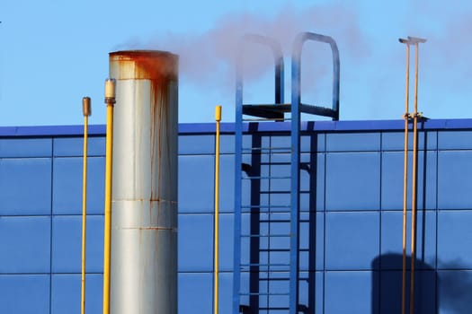 Industrial chimney, low angle view. Concept of heating in winter, environmental pollution.