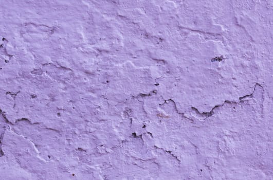 Damaged old plaster on wall in lilac color. Texture for design with copy space.