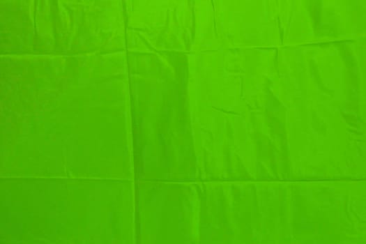 Green satin texture fabric shiny with pleats. Green texture for copy space design.