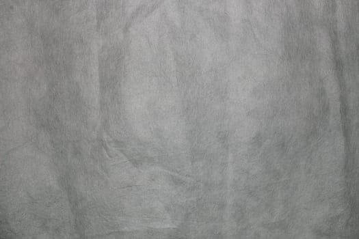 Texture of non-woven material in gray. Background for copy spaced designs.