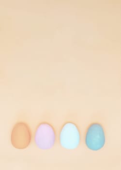 Brown, white, gray and lilac hand-painted decorative eggs on an uneven purple paper background. Spring holiday.