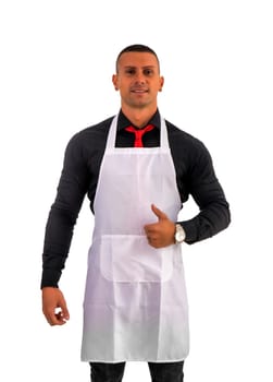 Attractive chef or waiter posing, wearing white apron and black shirt isolated on white background, in studio shot doing OK sign with thumb up