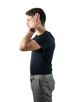 Depressed, sad or irritated young man covering ears with hands, in studio shot isolated on white