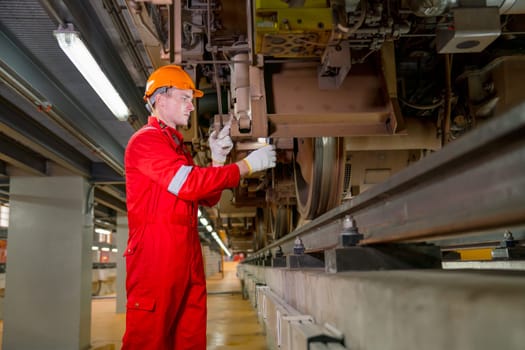 Professional technician worker hold light tube to check and maintenance part of train in electrical or metro train factory.