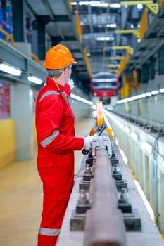 Vertical image and back of professional technician worker with safety uniform point to the electrical or sky train in factory workplace.