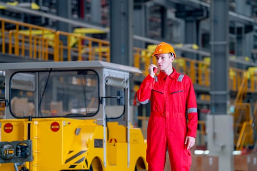 Close up professional technician worker stand near factory truck and use walkie talkie to contact his coworker in electrical or metro train factory.