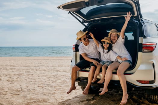 Family Day. Father, Mother and daughter enjoying road trip sitting on family back car raise hand up, Happy people having fun in summer vacation on beach, Family traveling in holiday at sea beach