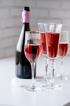 alcohol drinks concept. glasses of rose champagne on white table, white brick wall background