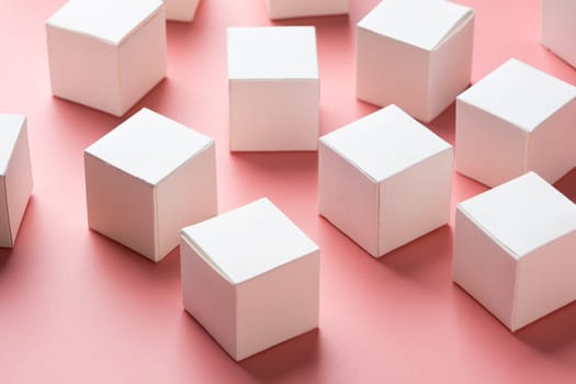 blank white block cubes on wooden table over light pink wall, Business communication concept