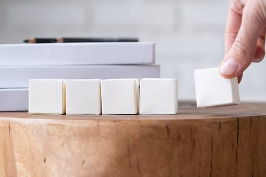 five blank white block cubes for writing a word on wooden table , Business communication concept