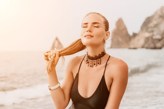 Side view a Young beautiful sensual woman in a mint long dress posing on a volcanic rock high above the sea during sunset. Girl on the nature on overcast sky background. Fashion photo